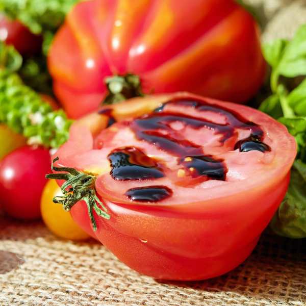 a tomato costoluto fiorentino sliced in half on a hessian table cloth